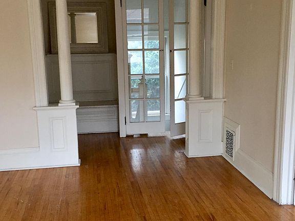 Entryway/stairwell seen from living room. Entry passage also has doors to front bedroom and into kitchen.