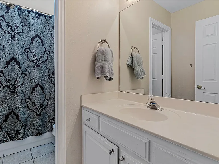 Bathroom vanity featuring white cabinetry, a single sink, and a light-toned countertop