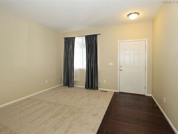 Hardwood entry into a newly carpeted Living room.
