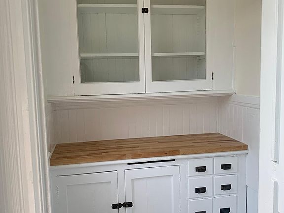 small butler's pantry off kitchen with original hardware and marble flooring