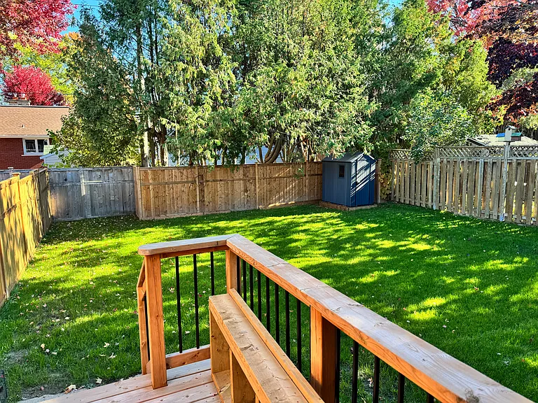 Large, fully fenced private backyard with a beautiful wooden deck_ideal for children and pets to play safely during your midterm stay.