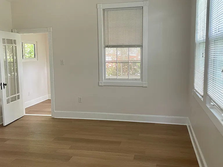 Living room view from the kitchen. The door leads to the bonus space. This is an excellent space for an office or a children's playroom. Lots of natural light and high ceilings.