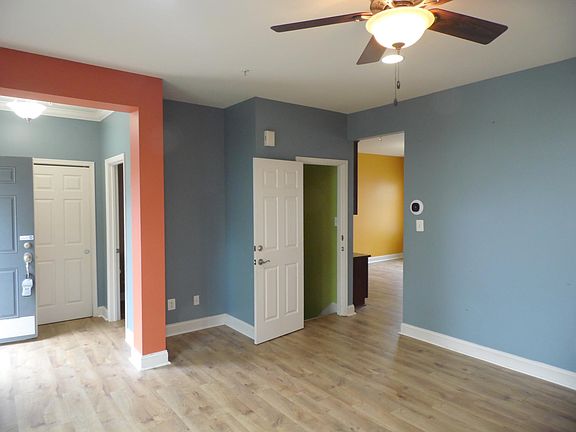 Living room looking toward half bath off entry and kitchen in rear