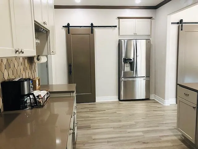 Another view of the kitchen and sliding barn door leads to pantry.