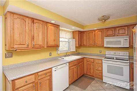 LOOK AT THIS KITCHEN FEATURING NEWER CABINETRY AND COUNTER TOPS, GORGEOUS CERAMIC TILE FLOORING, ALL KITCHEN APPLIANCES INCLUDING A SMOOTH TOP OVEN/RANGE, RECESSED SOFFIT LIGHTING, SPACIOUS PANTRY AND UPDATED KITCHEN LIGHTING!