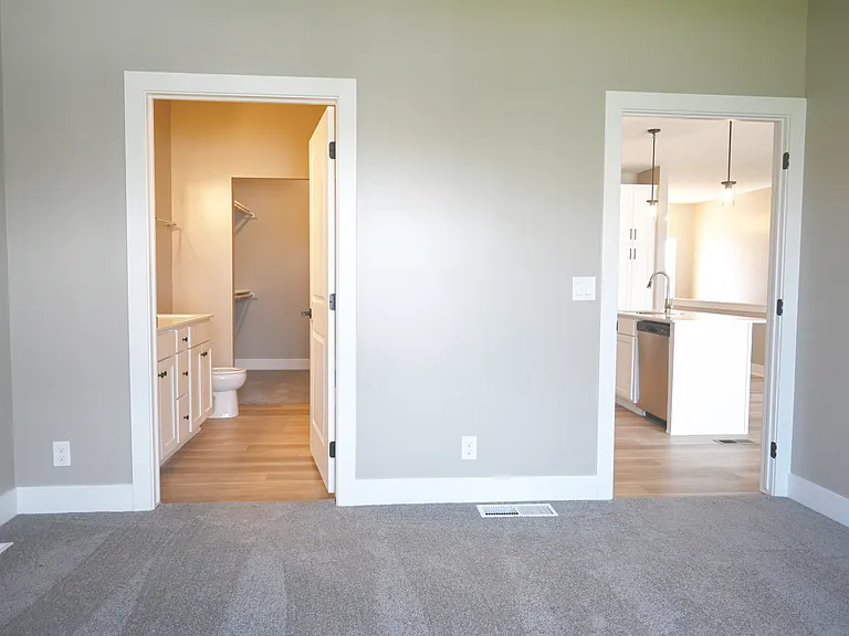Carpeted bedroom with bathroom attached.