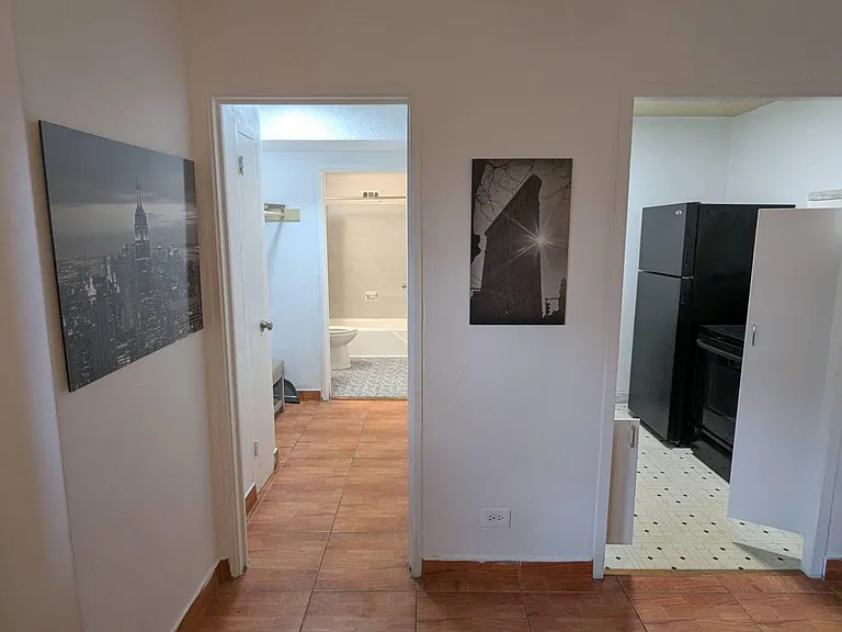 Central hallway connects the kitchen and a nearby full bath, offering easy access between shared living areas.