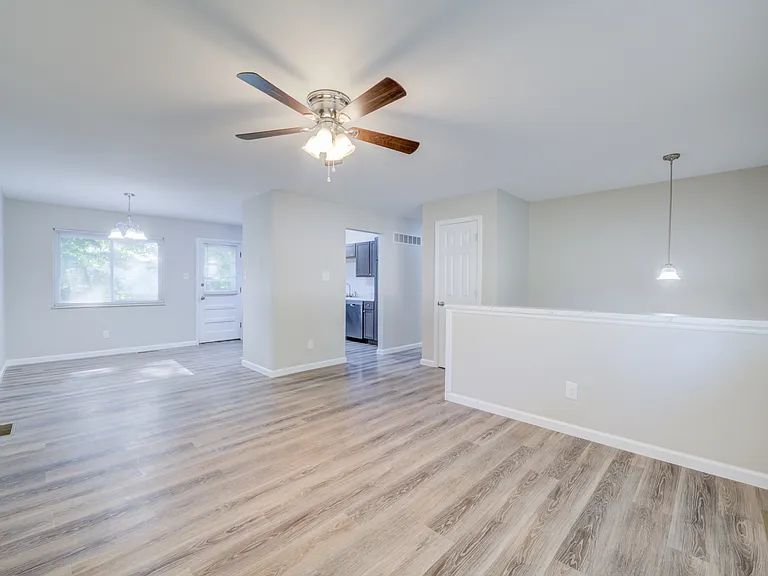 Living room is open to the dining area and kitchen. The door to the deck is in the background.