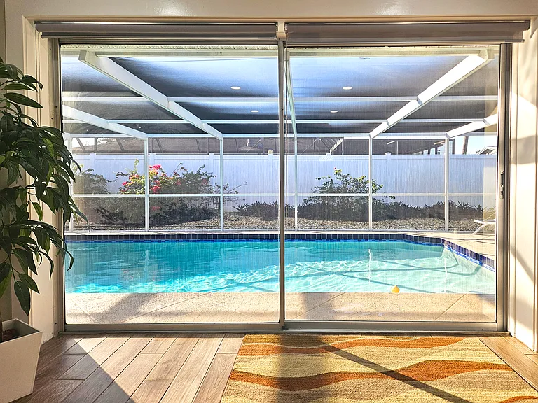 Double Sliding Doors Open to Screened Lanai & Pool