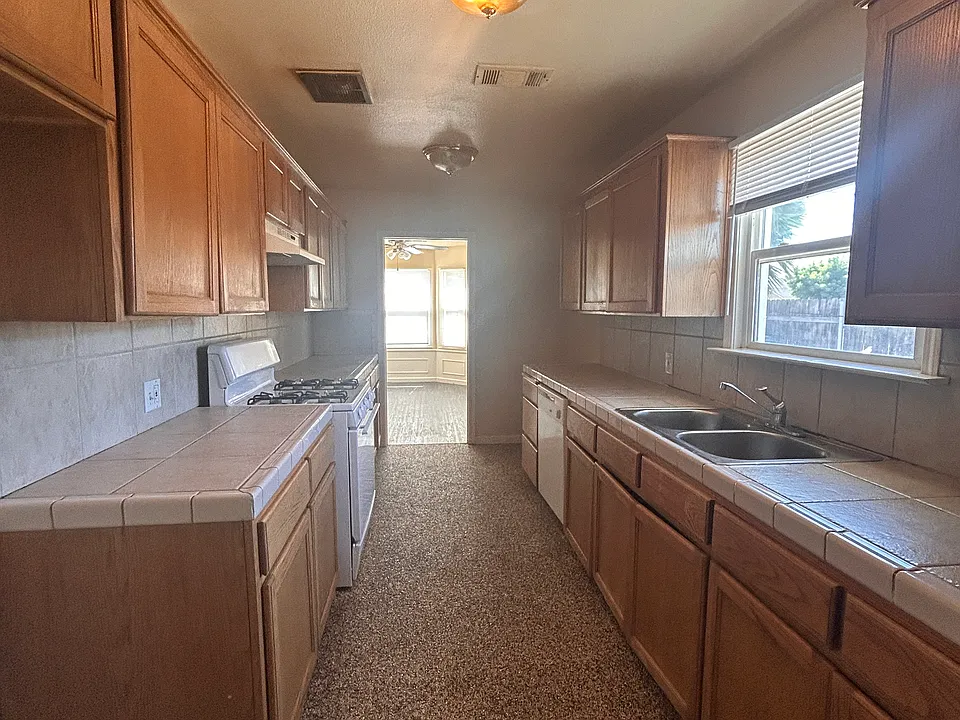 kitchen is loaded with counter tops right next to full indoor laundry room with additional space.