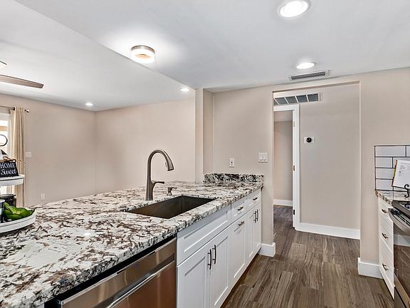 Kitchen features beautiful granite, white shaker cabinets, SS Appliances, recessed lighting & farm sink