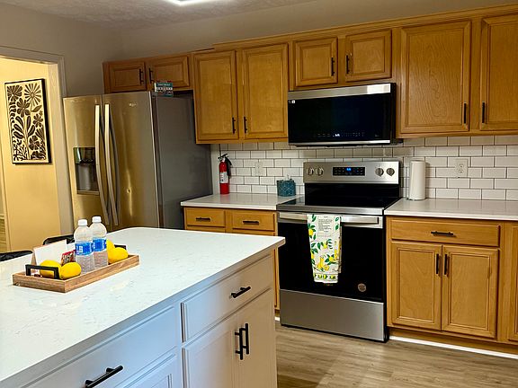 Spacious kitchen space with a well lit kitchen island and under cabinets lights