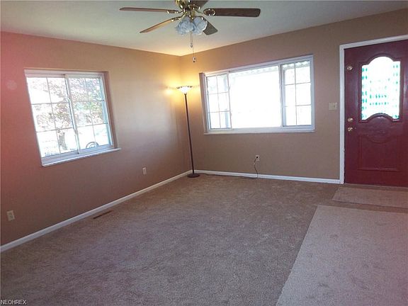 Living room offer ceiling fan, new carpet and large windows for good natural lighting.