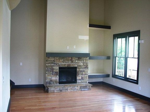 Two story living room with hardwood floors, fireplace, built-ins. Open and bright.