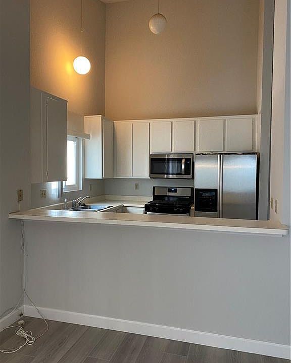 Freshly painted cabinets and stainless appliances.