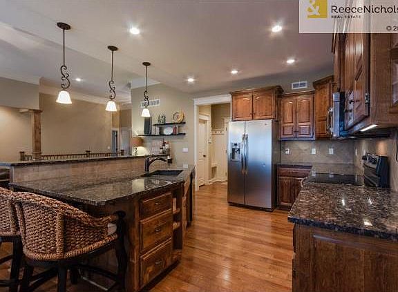 Oversized granite island serves as breakfast bar. Plenty of stor