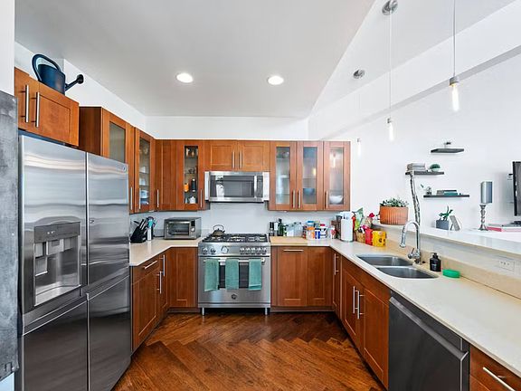 Kitchen with updated appliances including Bertazzoni gas oven, dual sink, dishwasher, and LG refrigerator. Great for hosting with open floor plan to living room and dining area.