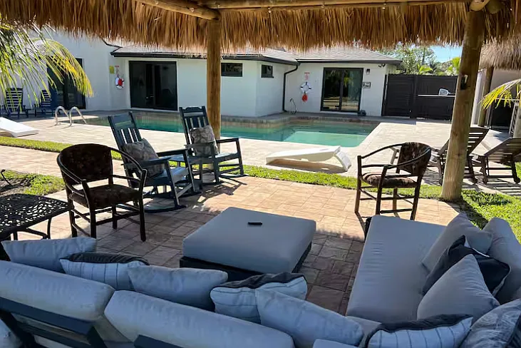 View of tiki sitting area behind pool