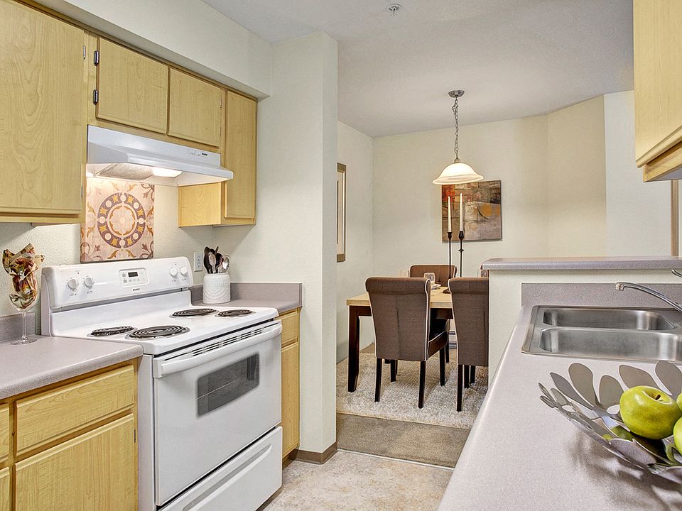 Open kitchen with dishwasher, double sinks, and plenty of cabinet storage and counter space