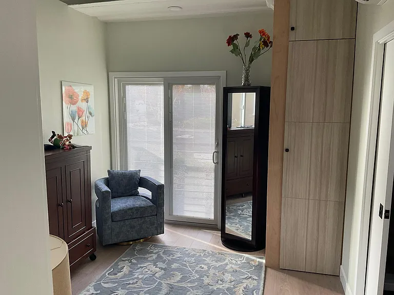 Bedroom #2 with queen-sized Murphy bed folded up, full-length mirror swivels to have storage on the other side