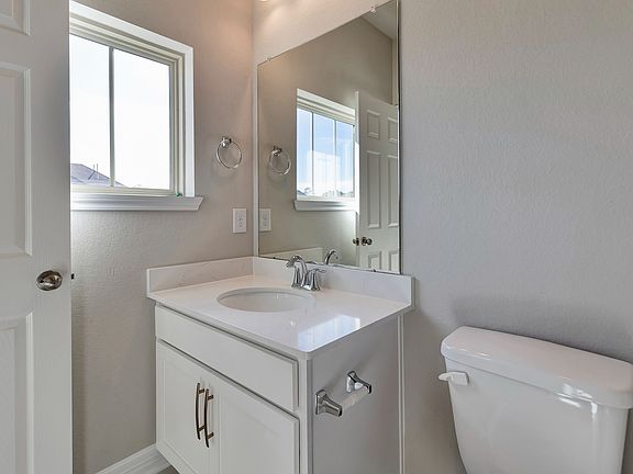 The private bath features tile flooring bath shower combo with tile surround.