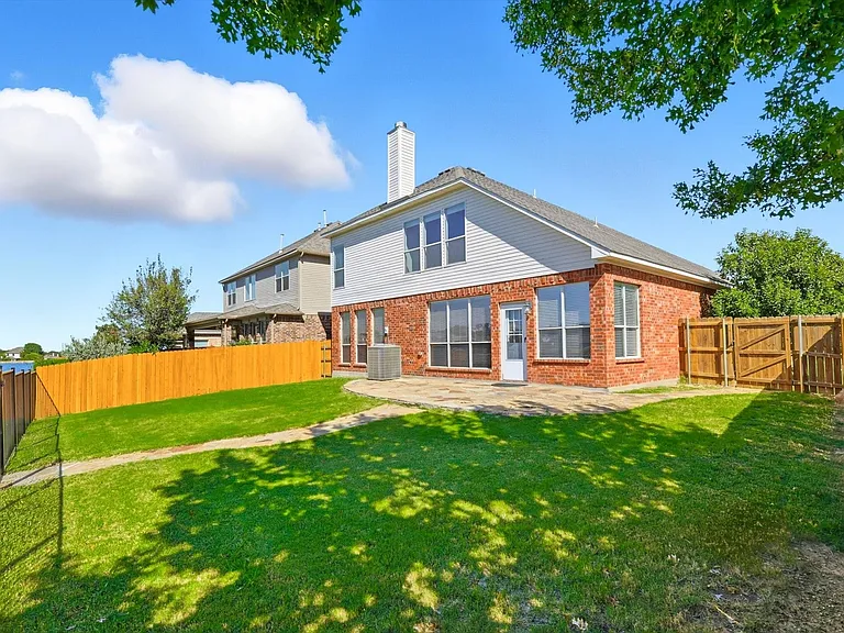 View of the back of home with a patio that looks out onto the water