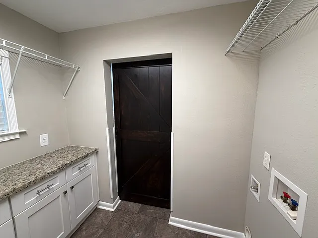 Laundry room with barn door in closed position. Gas & electric hookups