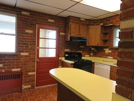 Kitchen entrance from mud room, stove, dishwasher, cupboards and peninsula