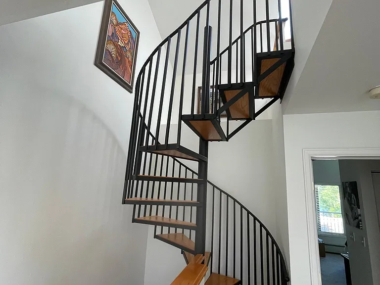 Spiral staircase to loft. Desks, printer, and futon in loft.