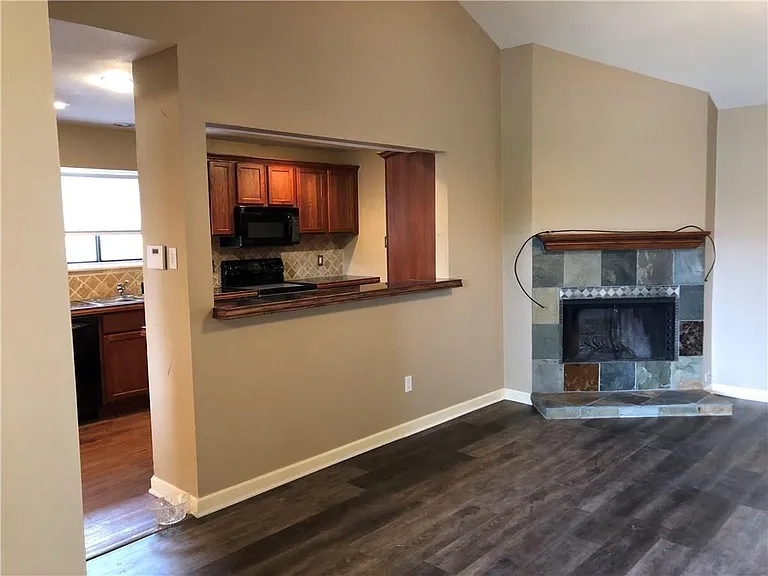 The living room has a wood-burning fireplace and a pass-through bar to the kitchen.