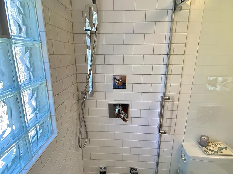Just renovated luxe master bath. Radiant natural slate stone floors, multiple sprayers, rain shower head, linen closet, designer commode, marble topped vanity, and more. Flooded with light, just right.