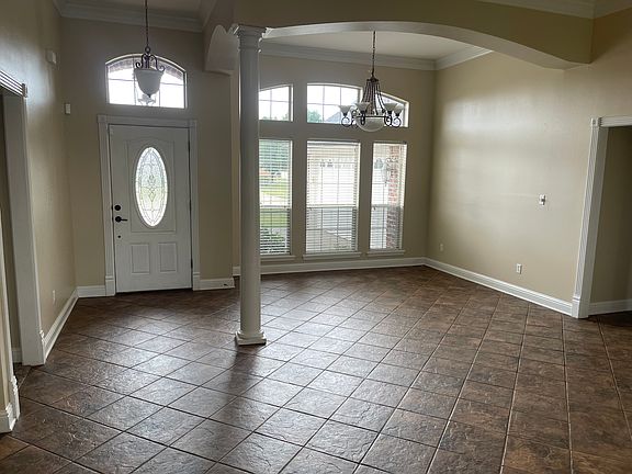 Dining room, high ceilings, crown molding, ceramic tile, view to remote primary, laundry & kitchen