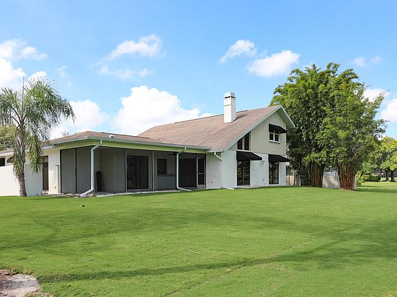 Beautiful expansive backyard with shading from bamboo trees. Located on the prestigious Feather Sound Country Club's 11th and 14th hole.