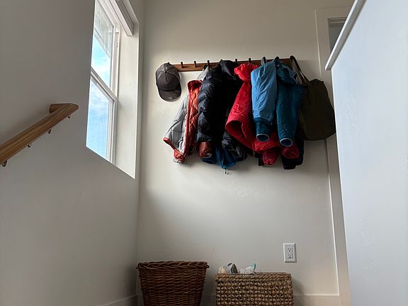 Coat hooks installed at the top of the stairs.