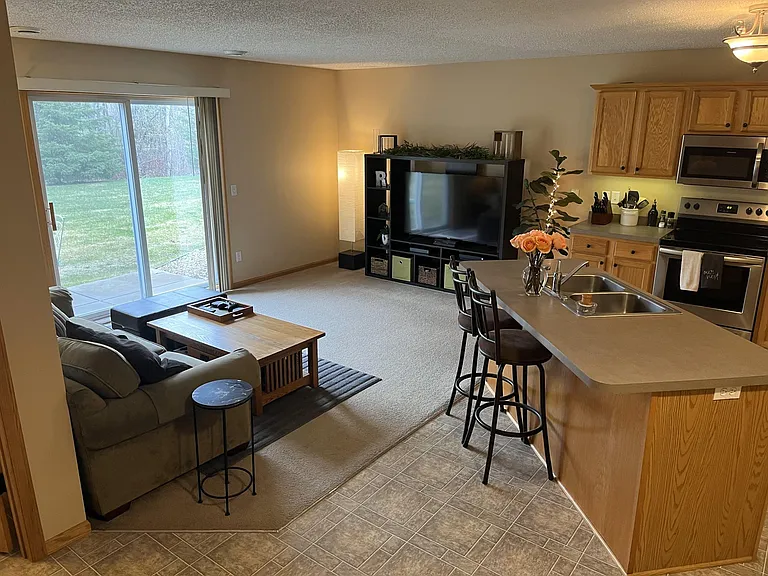 Living room with view to the patio and wooded backyard.
