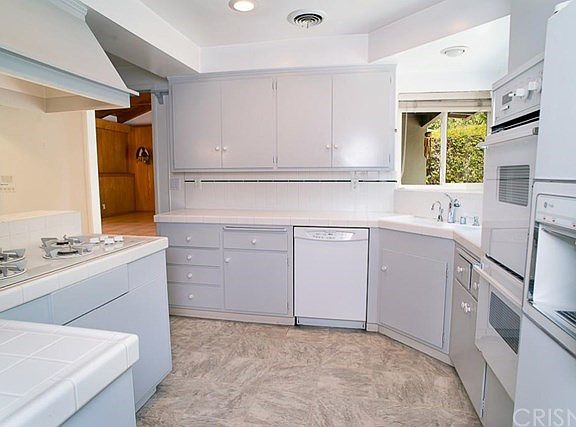 The kitchen boasts a gas range, electric oven, a dishwasher, and recessed lights.