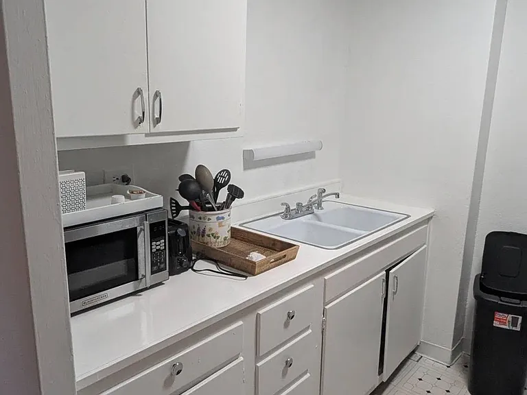 Efficient kitchen workspace with ample cabinet storage, laminate counters, and a double-basin sink for easy meal prep.