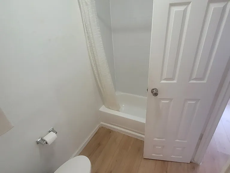 Upstairs toilet and shower, connected to alley-facing bedroom (right door) and sink (behind camera-view)