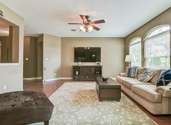 Open living room with windows that look out to the backyard