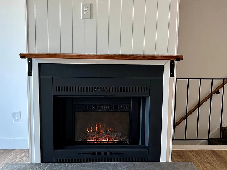 Electric fireplace; outlet and wall support above fireplace mantel for mounting a TV
