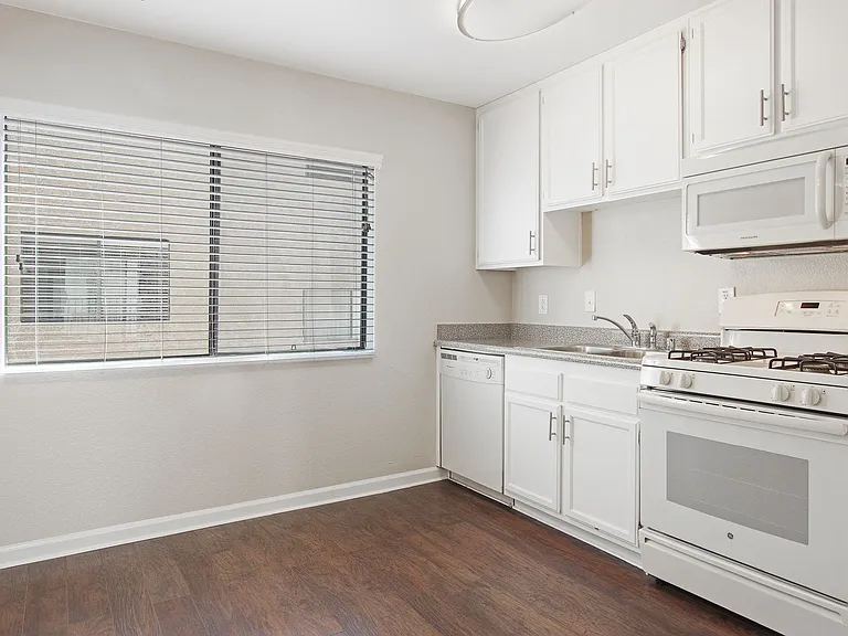 Kitchen with white cabinetry and appliances