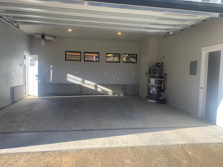 Large garage with 10' ceiling and 21' long. Can accommodate most full-size trucks. Built in floor drains. Hot and Cold Water hose bib.