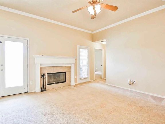 Living room with fireplace. Master bedroom straight ahead next to window. Exit to backyard through the door on the left.