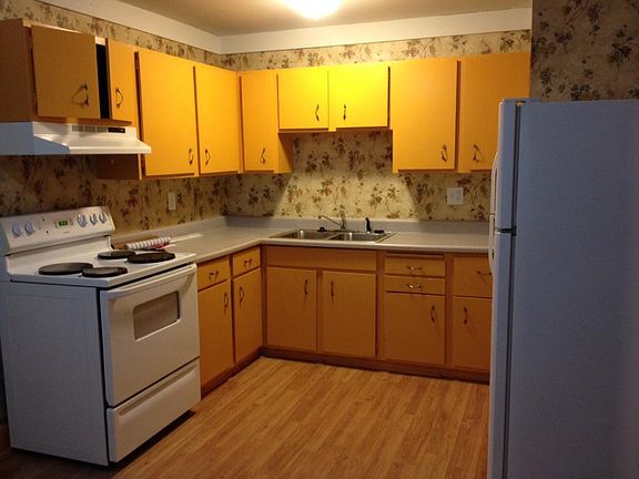 Here's the kitchen. 
The front yard has a low wood fence framing the outer driveway area with pebbles on the area expanding the width of the driveway..