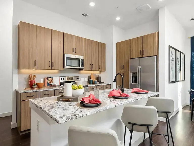 Apartment Kitchen with Granite Island, Bar Stools, and Stainless Appliances