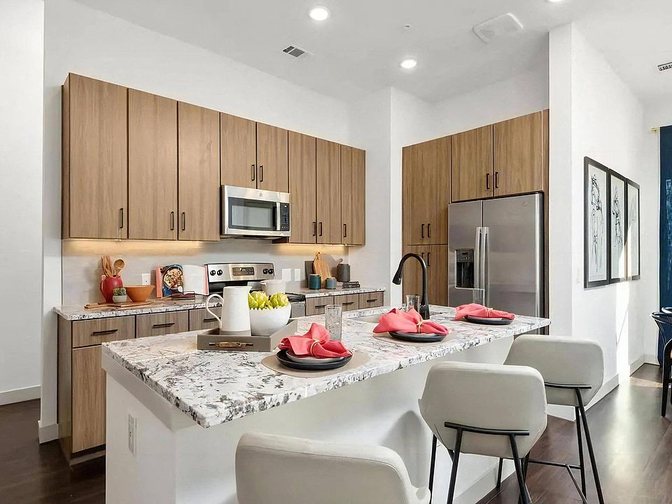 Apartment Kitchen with Granite Island, Bar Stools, and Stainless Appliances
