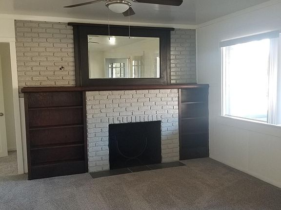 Half of living room showing book selves and fireplace.