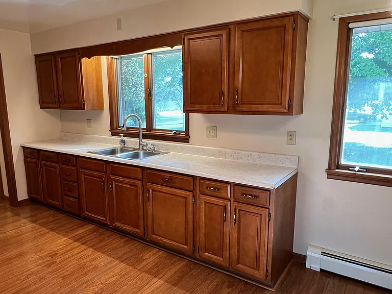 Window over sink looking into backyard. New Pull out faucet 2022. Also hard water tap on sink for those who must watch their salt intake from softened water.