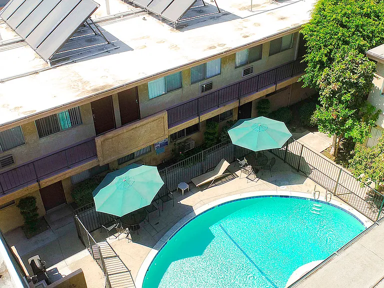 Aerial view of gated community pool with lounging space.