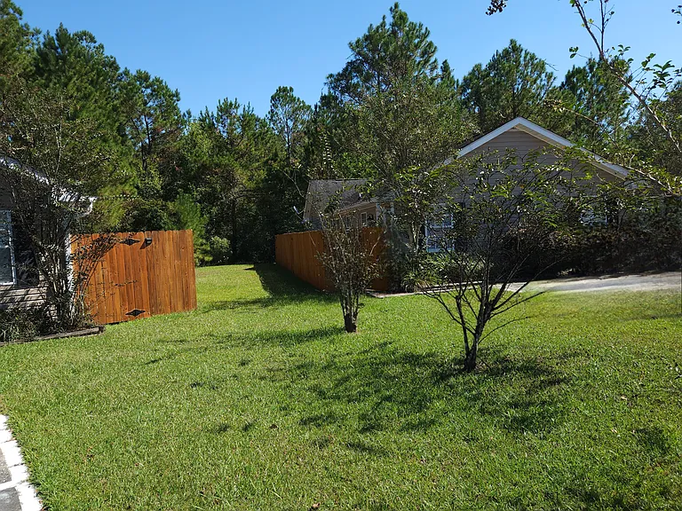 COMPLETEY FENCED IN WITH TREE COVERED LOT BEHIND UNIT